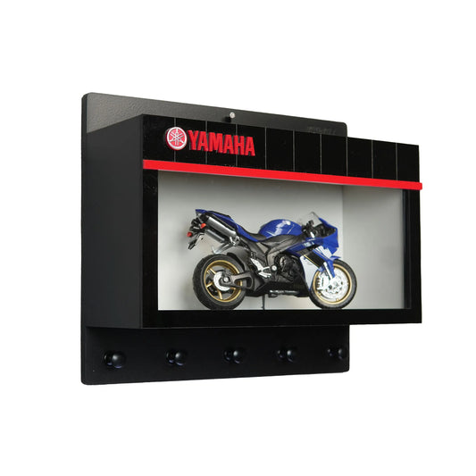 Black Yamaha wall key hook rack with red logo and scale model blue sport motorcycle inside display case.