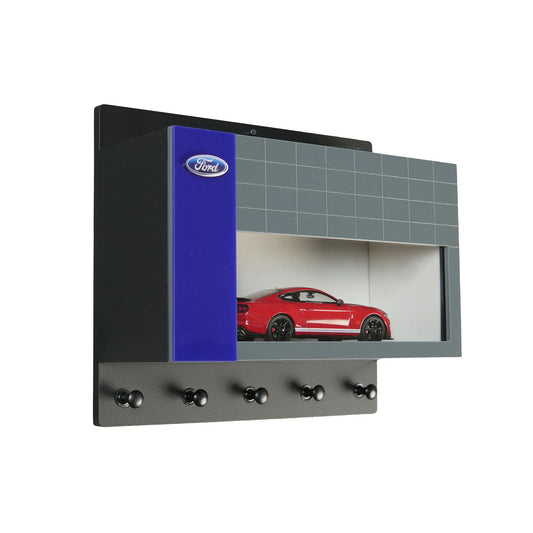 Wall-mounted Ford key hook rack with blue and gray design and red scale model car display shelf.