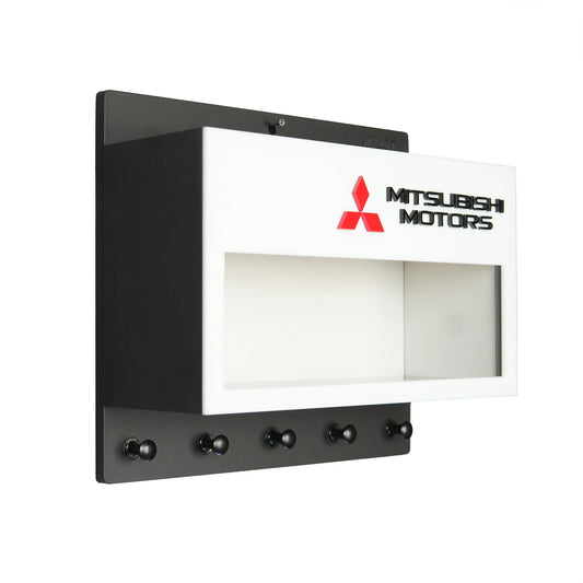 Black and white Mitsubishi Motors wall-mounted key hook rack with five hooks and display case slot.