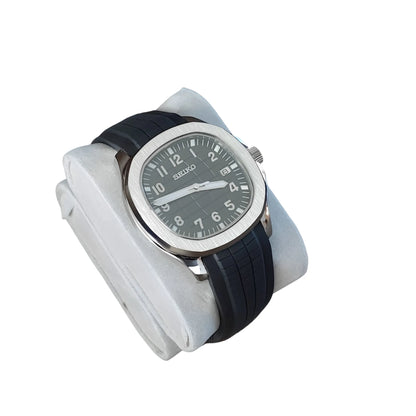Seiko Aquanaut watch with 40mm silver stainless steel case, black dial, white numerals, and black rubber strap.