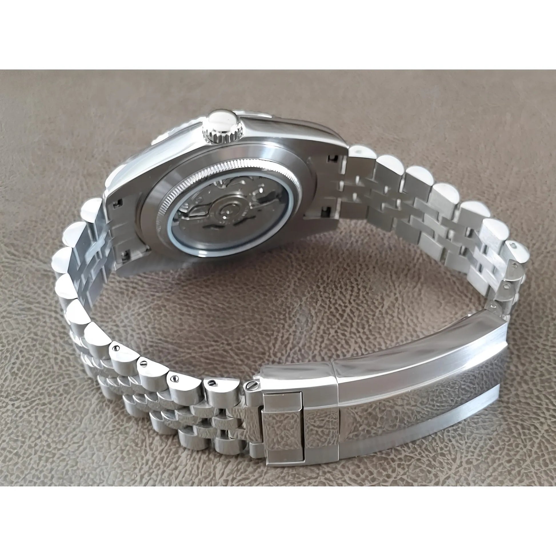 Stainless steel Seiko watch with exhibition case back and linked metal bracelet clasp.