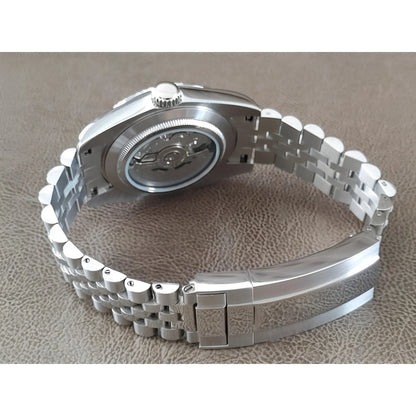 Stainless steel Seiko watch with exhibition case back and linked metal bracelet clasp.