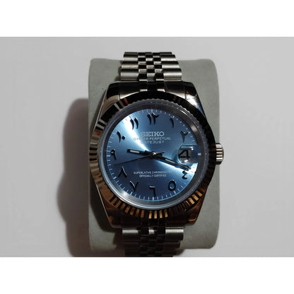 Seiko watch with ice blue dial, black Arabic numerals, chromed hour markers, date window, fluted bezel, and stainless steel.