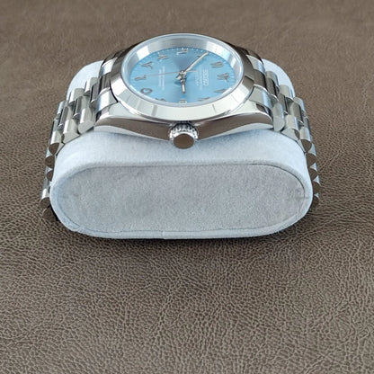 Seiko wristwatch with 39mm platinum case, fluted bezel, ice blue dial, Arabic numerals, and silver Jubilee bracelet on gray.