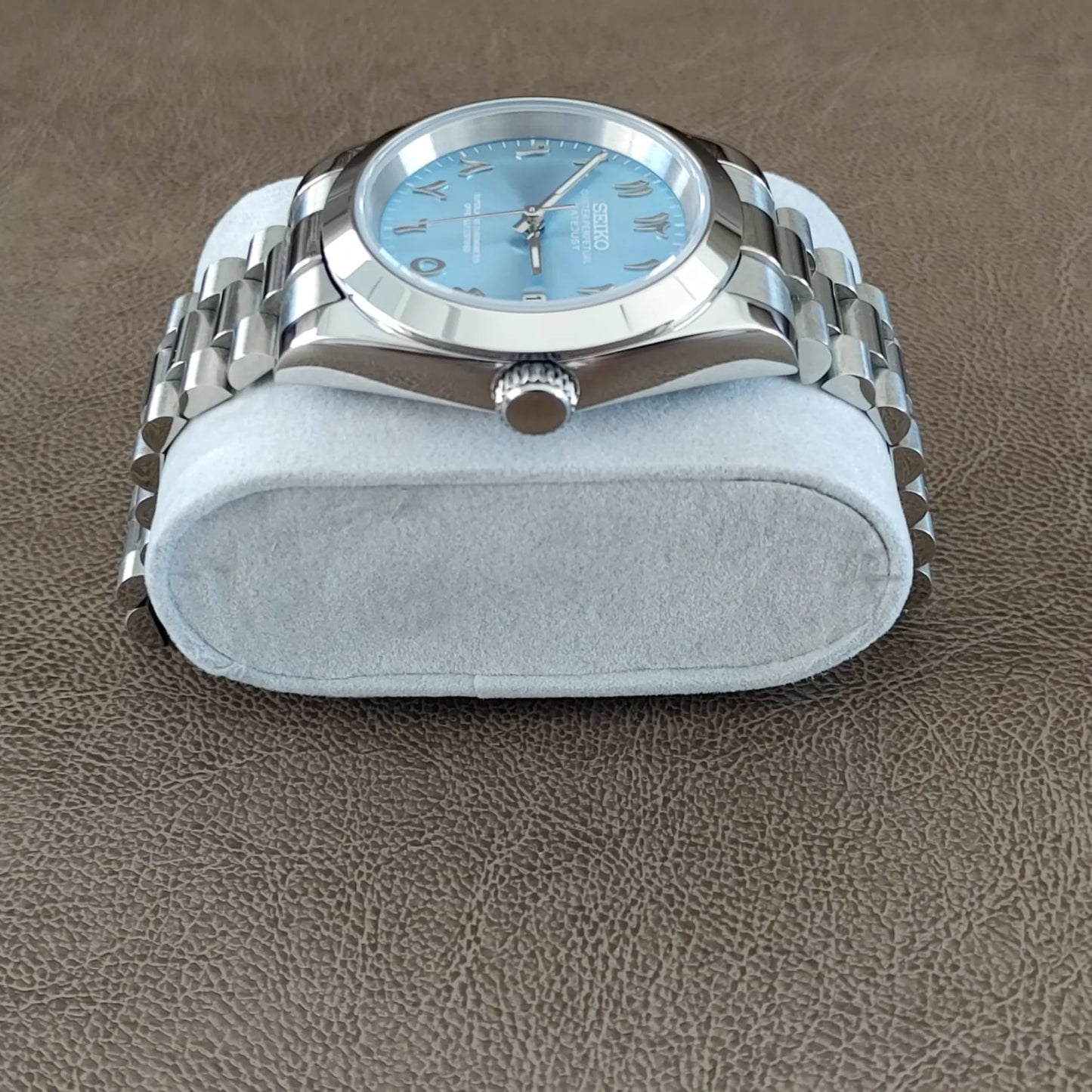 Seiko wristwatch with 39mm stainless steel case, ice blue dial with Arabic numerals, and polished President-style bracelet.