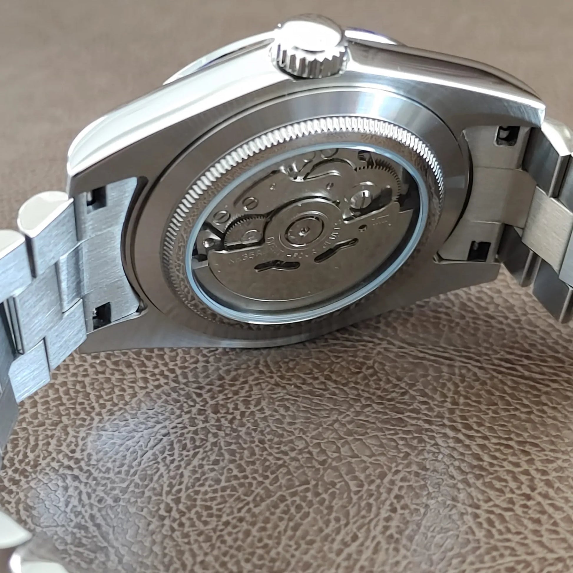 Stainless steel watch back with visible automatic movement and President bracelet links.