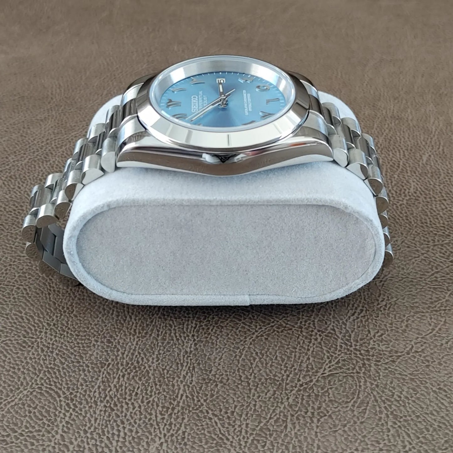 39mm Seiko watch with platinum fluted bezel, ice blue dial, Arabic numerals, and silver Jubilee bracelet.