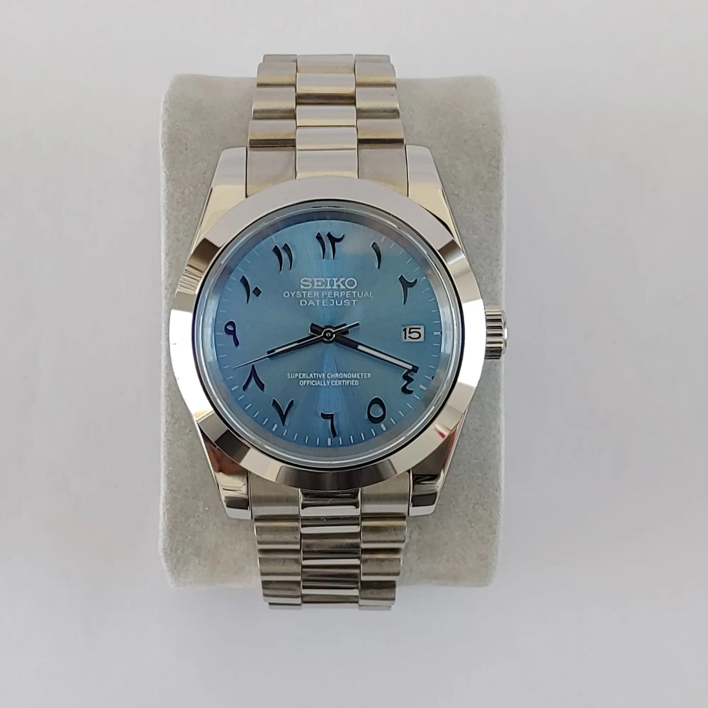Seiko 39mm watch with ice blue Arabic dial and stainless steel president bracelet strap.