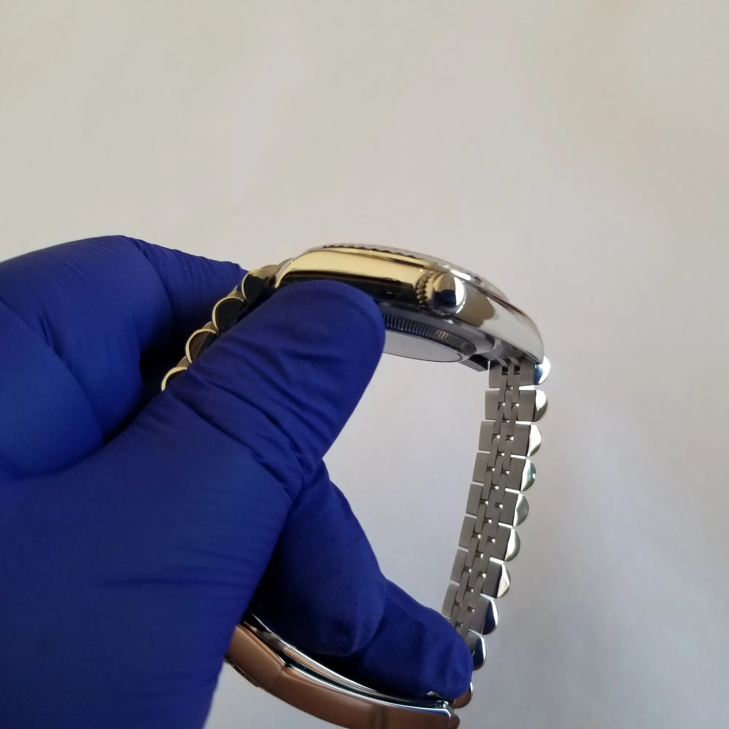 Silver stainless steel watch with fluted bezel, ice blue dial, white Arabic numerals, and linked metal bracelet.