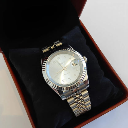 Silver stainless steel watch with fluted bezel, ice blue dial, white Arabic numerals, and two-tone metal bracelet displayed.