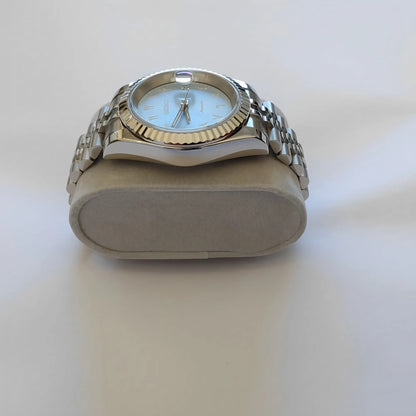 Seiko wristwatch with 39mm ice blue dial, white Arabic numerals, fluted silver bezel, and stainless steel bracelet.
