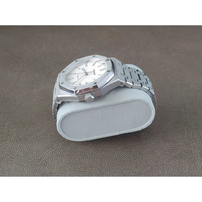 Silver stainless steel watch with frosted white dial, octagonal bezel, and linked bracelet on light gray cushion.