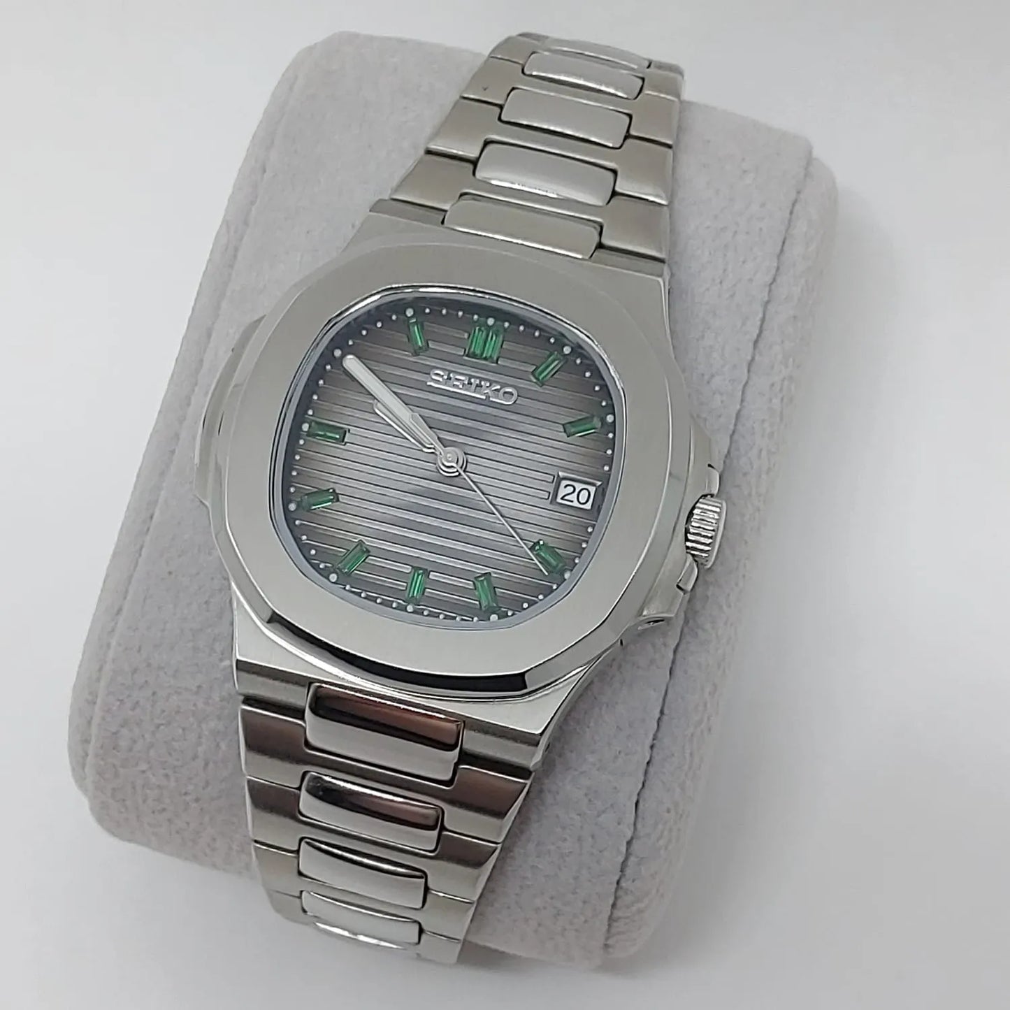 Seiko stainless steel watch with emerald baguette hour markers and horizontal striped gray dial.