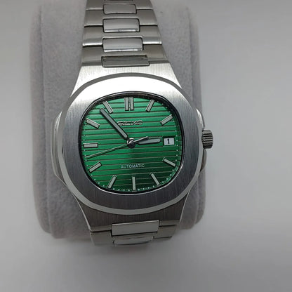 Stainless steel watch with green textured dial, silver hour markers, and integrated metal bracelet.