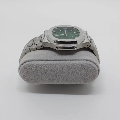Silver stainless steel Seiko Nautilus watch with green dial and silver hour markers on gray cushion.