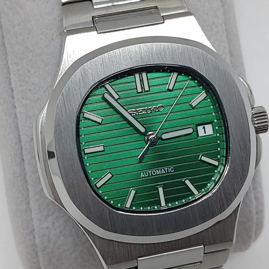 Seiko watch with 40mm stainless steel case, green textured dial, silver hour markers, and date window at three o'clock.