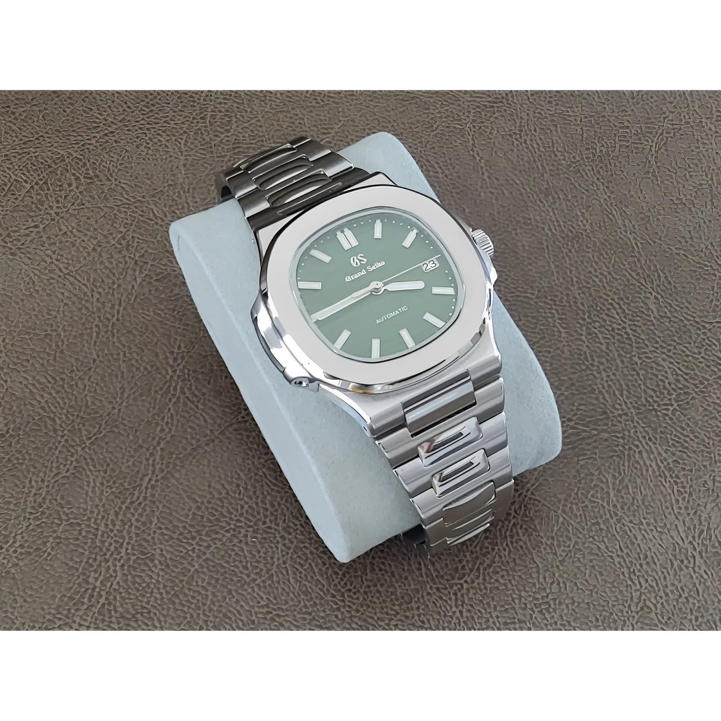 Stainless steel 40mm Seiko watch with olive green dial, silver hour markers, and bracelet strap on gray cushion.