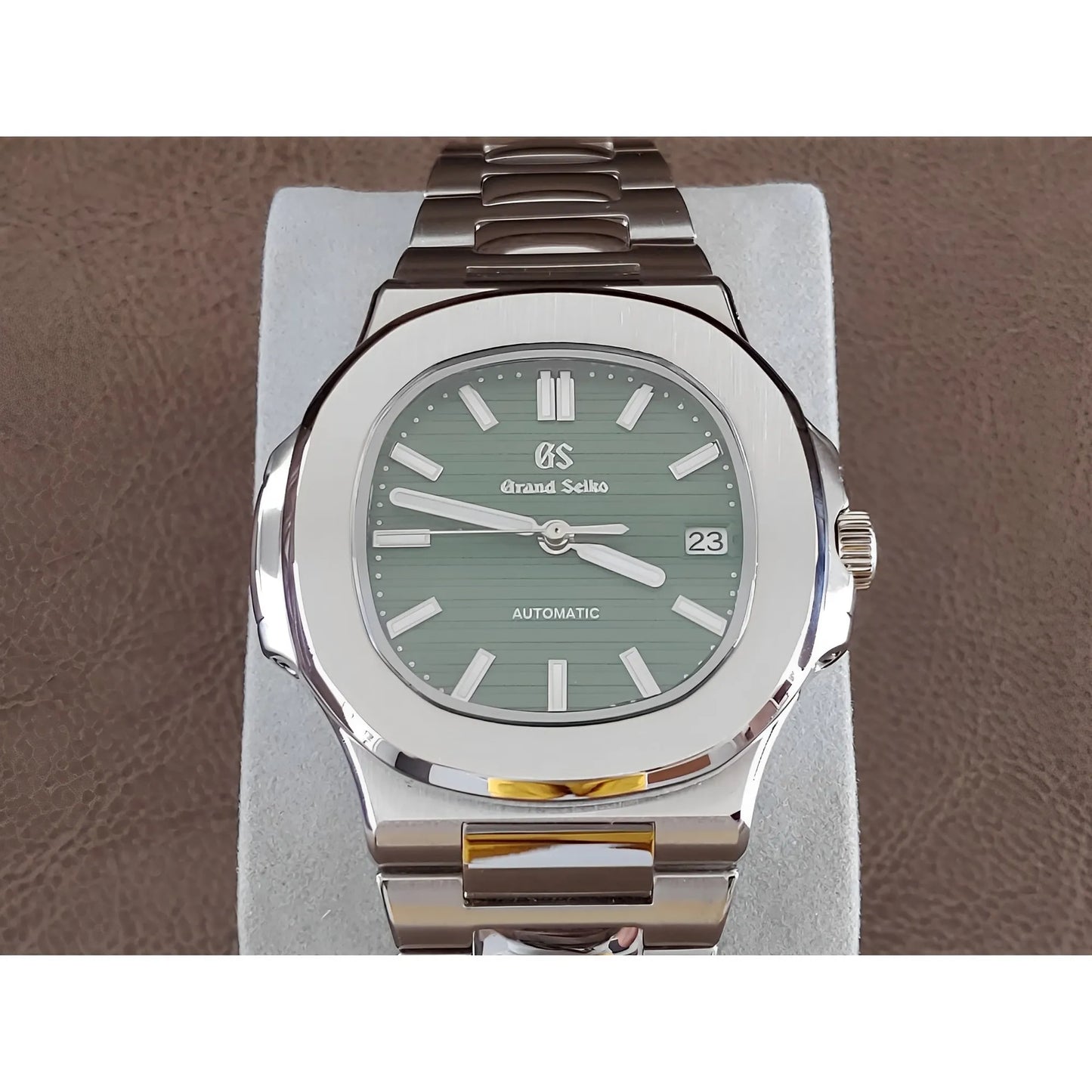 Seiko NH35 wristwatch with olive green dial, stainless steel case and bracelet, luminous markers, and date display at 3.