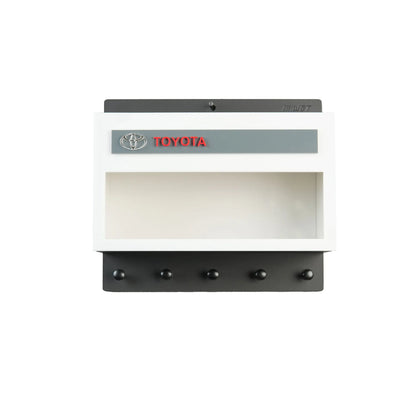 White and black Toyota wall key hook rack with display shelf and five black hooks.