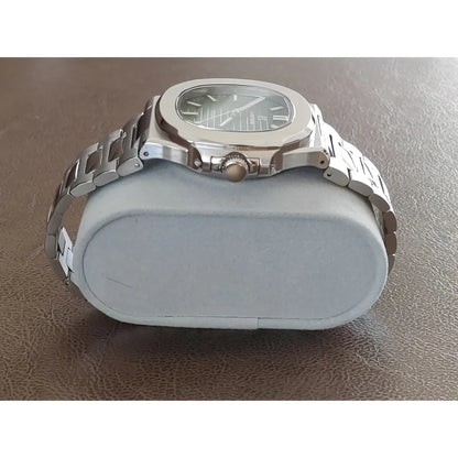 Seiko NH35 watch with 40mm stainless steel case, olive green dial, and integrated metal bracelet on gray cushion.