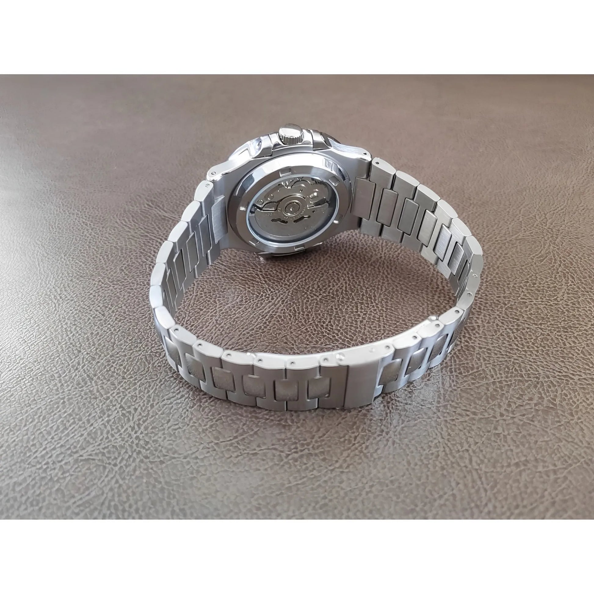 Silver stainless steel wristwatch with a round olive green dial and linked bracelet band.