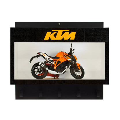 Black wall key hook rack with a clear display case featuring an orange KTM scale model motorcycle and three lower hooks.