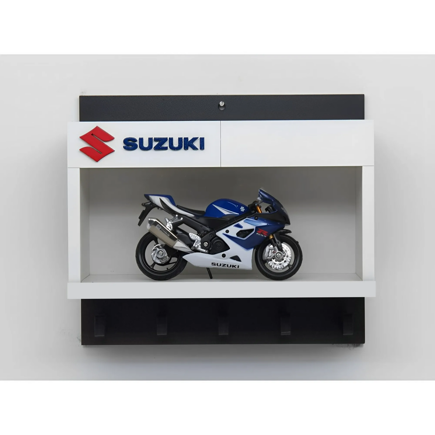 White and black wall key hook rack featuring a detailed blue and silver Suzuki scale model motorcycle and Suzuki logo panel.