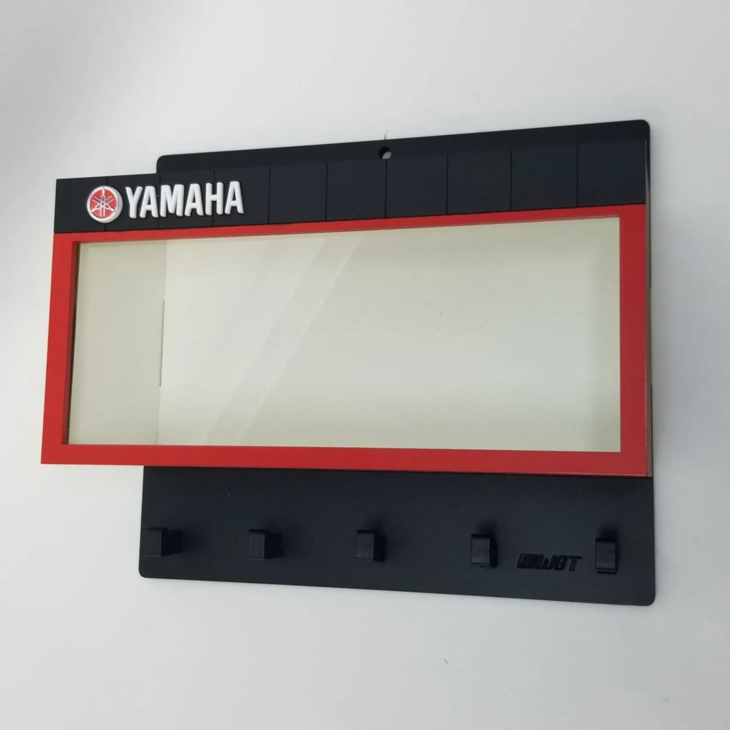 Black Yamaha wall key hook rack with five hooks and a rectangular red-bordered display case panel.