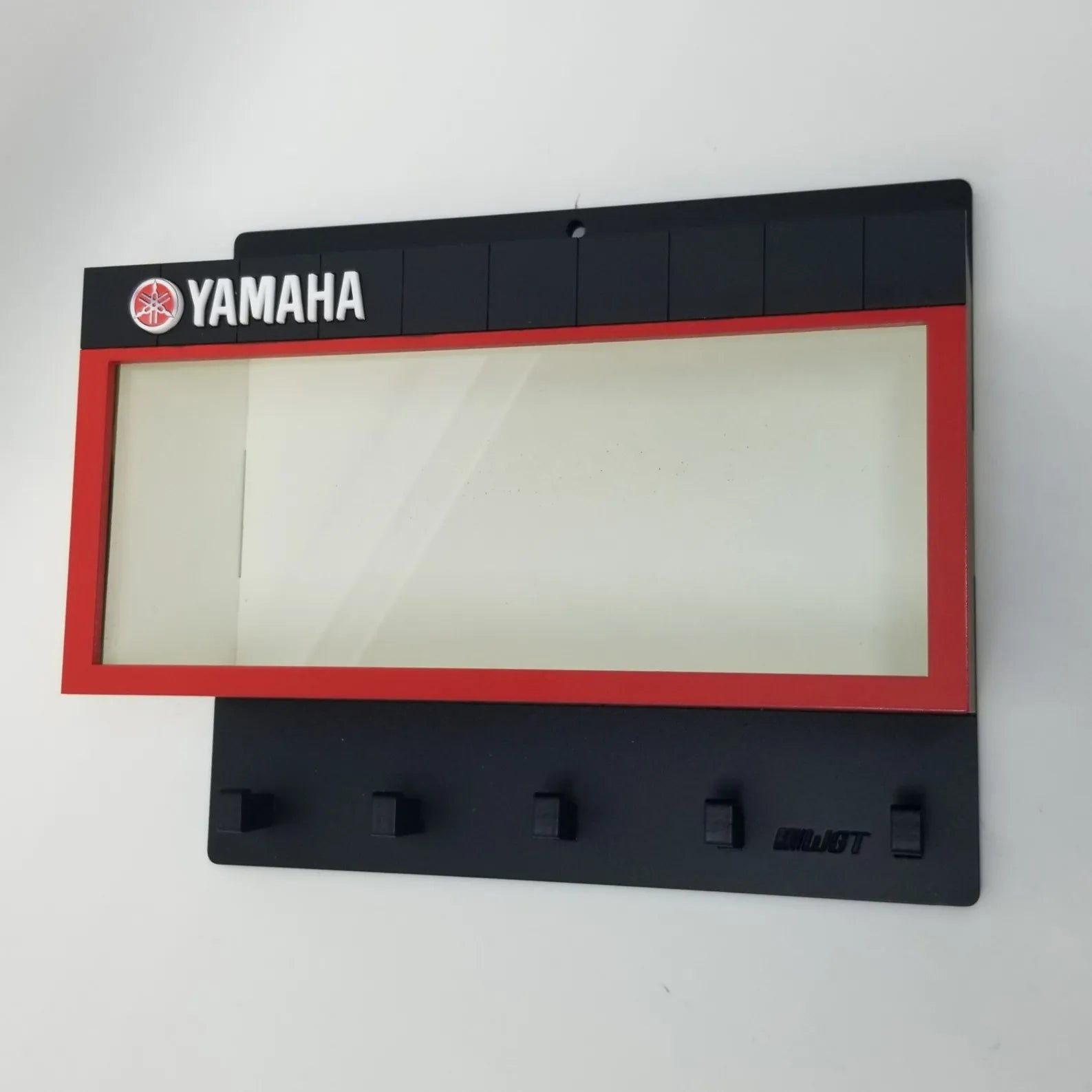 Black Yamaha wall key hook rack with five hooks and a rectangular red-bordered display case panel.