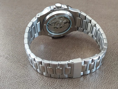 Seiko stainless steel watch with polished bracelet and transparent case back showing mechanical movement.