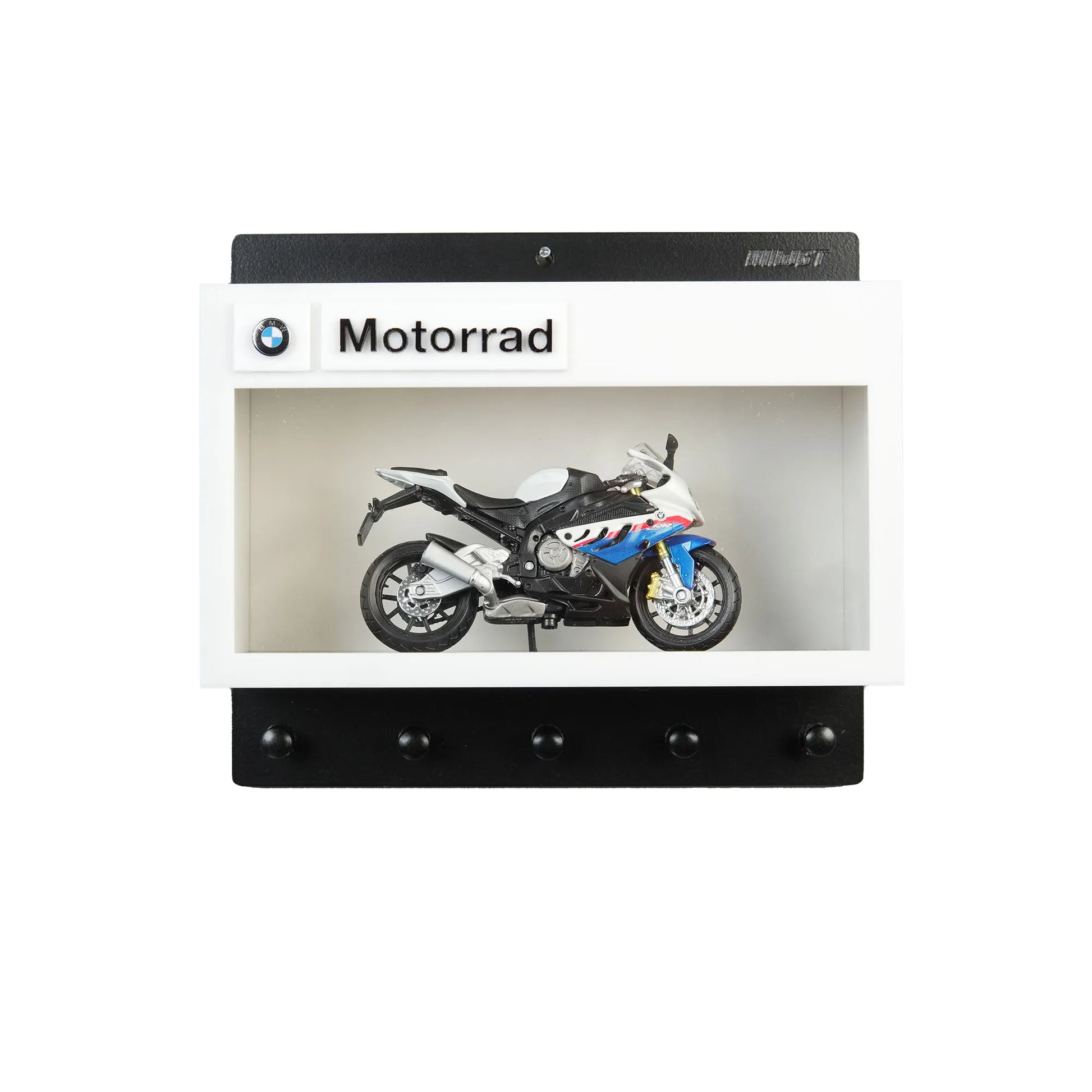 BMW Motorrad wall-mounted key hook rack with black and white frame and a miniature sport motorcycle model inside.