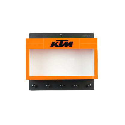 Orange and black KTM wall-mounted key hook rack with four metal hooks and a display shelf above the hooks.