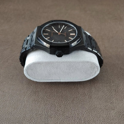 Black dial watch with rose gold hour markers and hands, octagonal bezel, stainless steel bracelet.