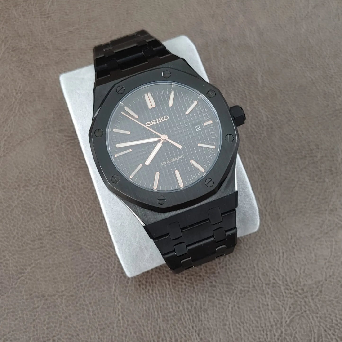 Black stainless steel Royal Oak style watch with 41mm octagonal bezel and rose gold hour markers and hands on textured black
