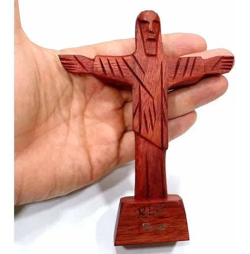 Hand-carved Cristo Redentor statue in reddish Brazilwood, 19cm tall, with outstretched arms on a rectangular base.