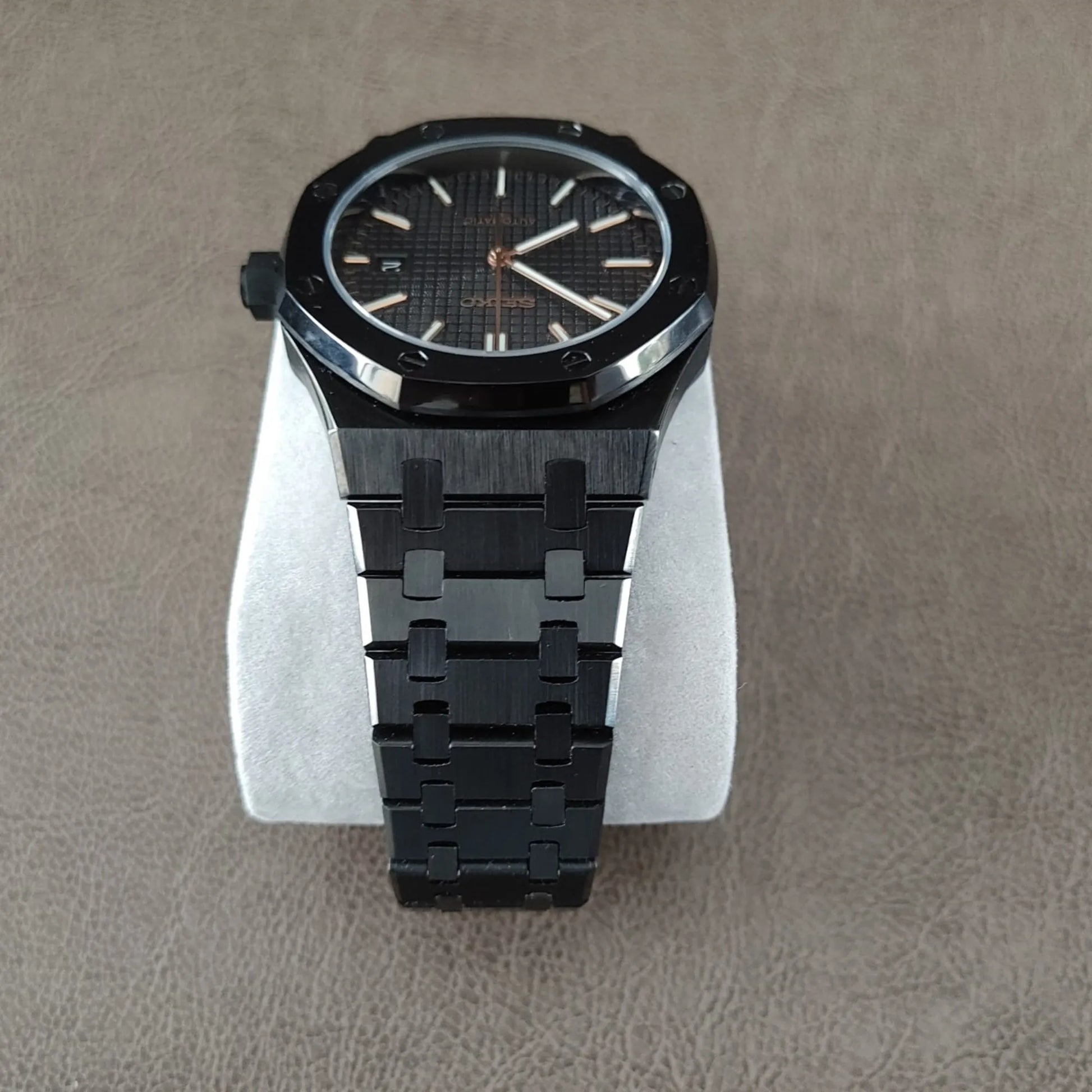 41mm black royal oak style watch with rose gold hands and hour markers, black metal bracelet.