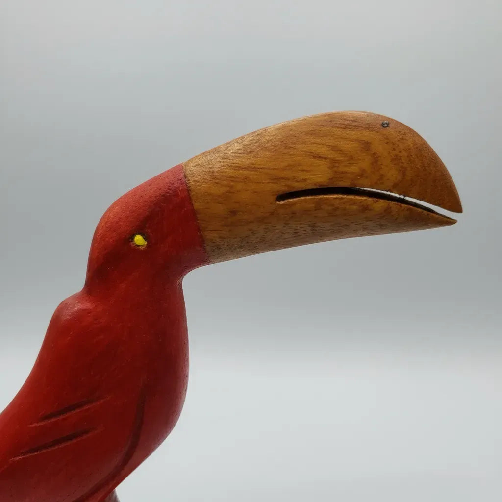 Red and natural wood handcrafted toucan sculpture with detailed carved wings and a long curved beak.