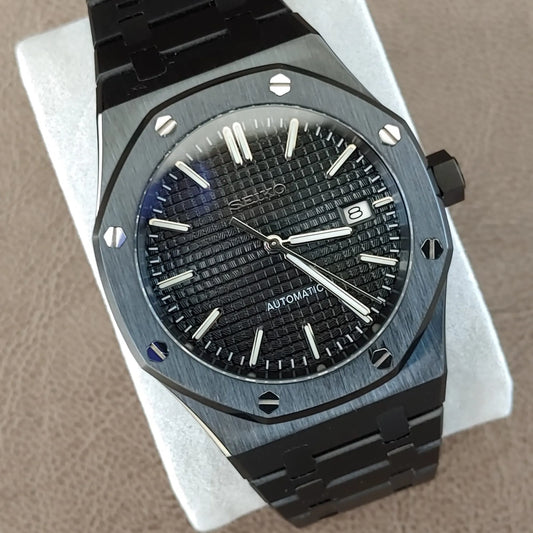 Black and silver Seiko NH35 Royal Oak watch with textured black dial, date window, and stainless steel bracelet.