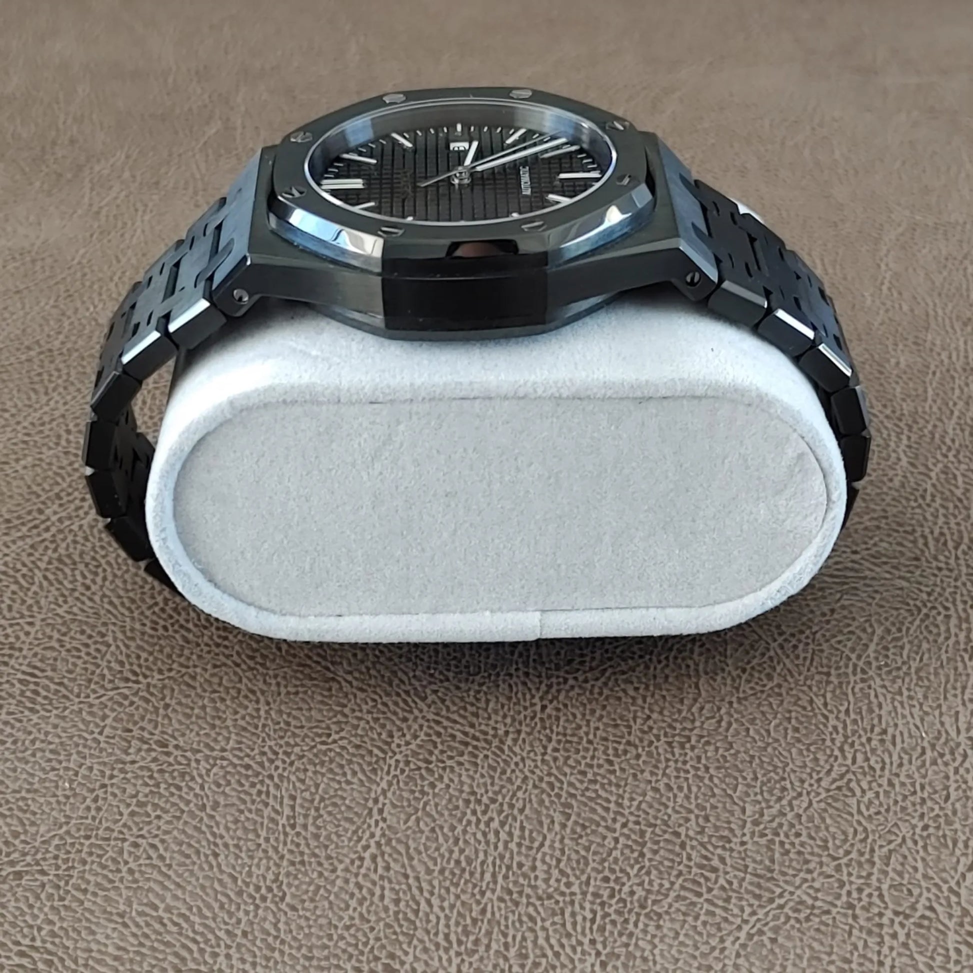Seiko NH35 black and silver 41mm watch with a textured dial and metal bracelet resting on a white cushion.