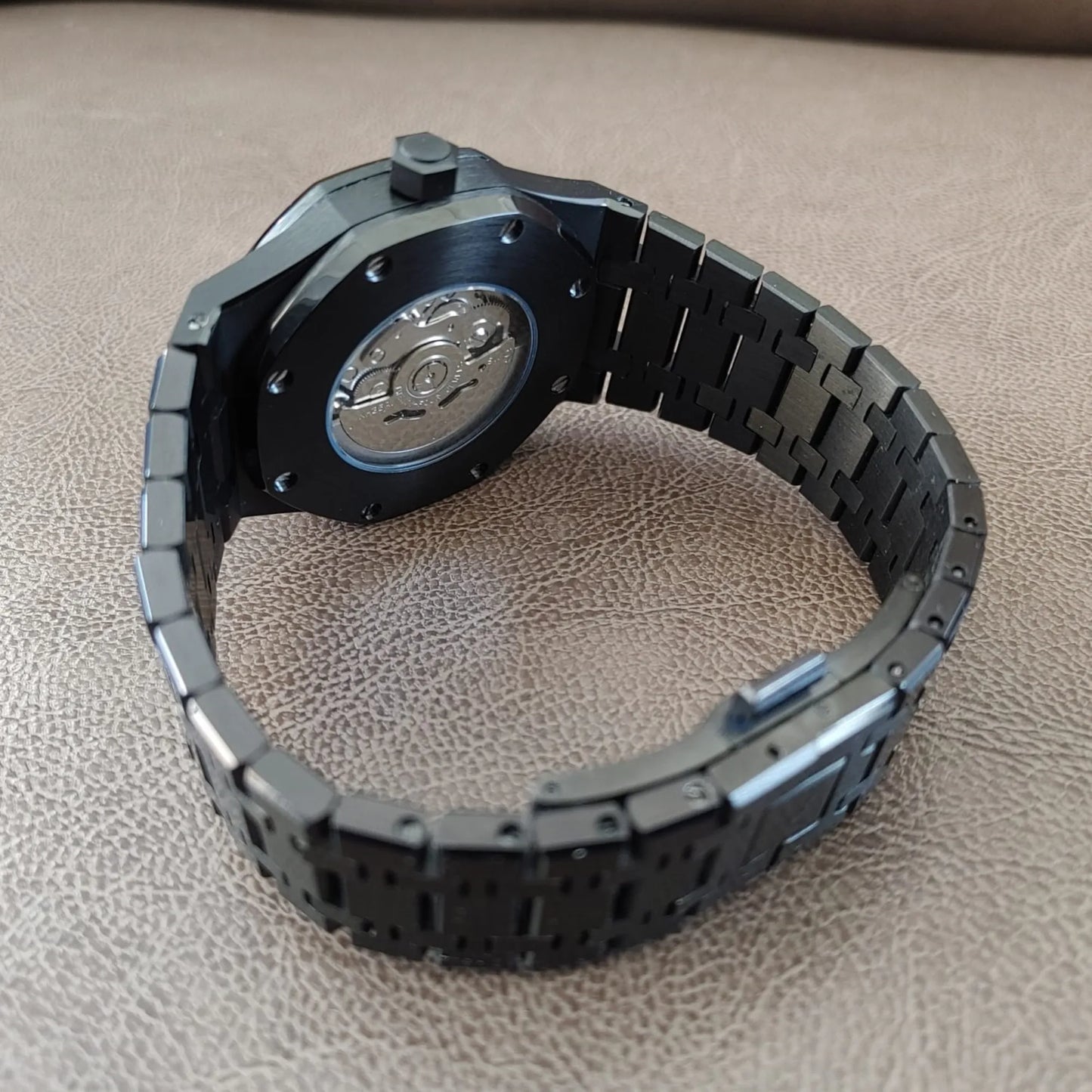 Black and silver 41mm Seiko Royal Oak watch with stainless steel bracelet and transparent case back showcasing the movement.