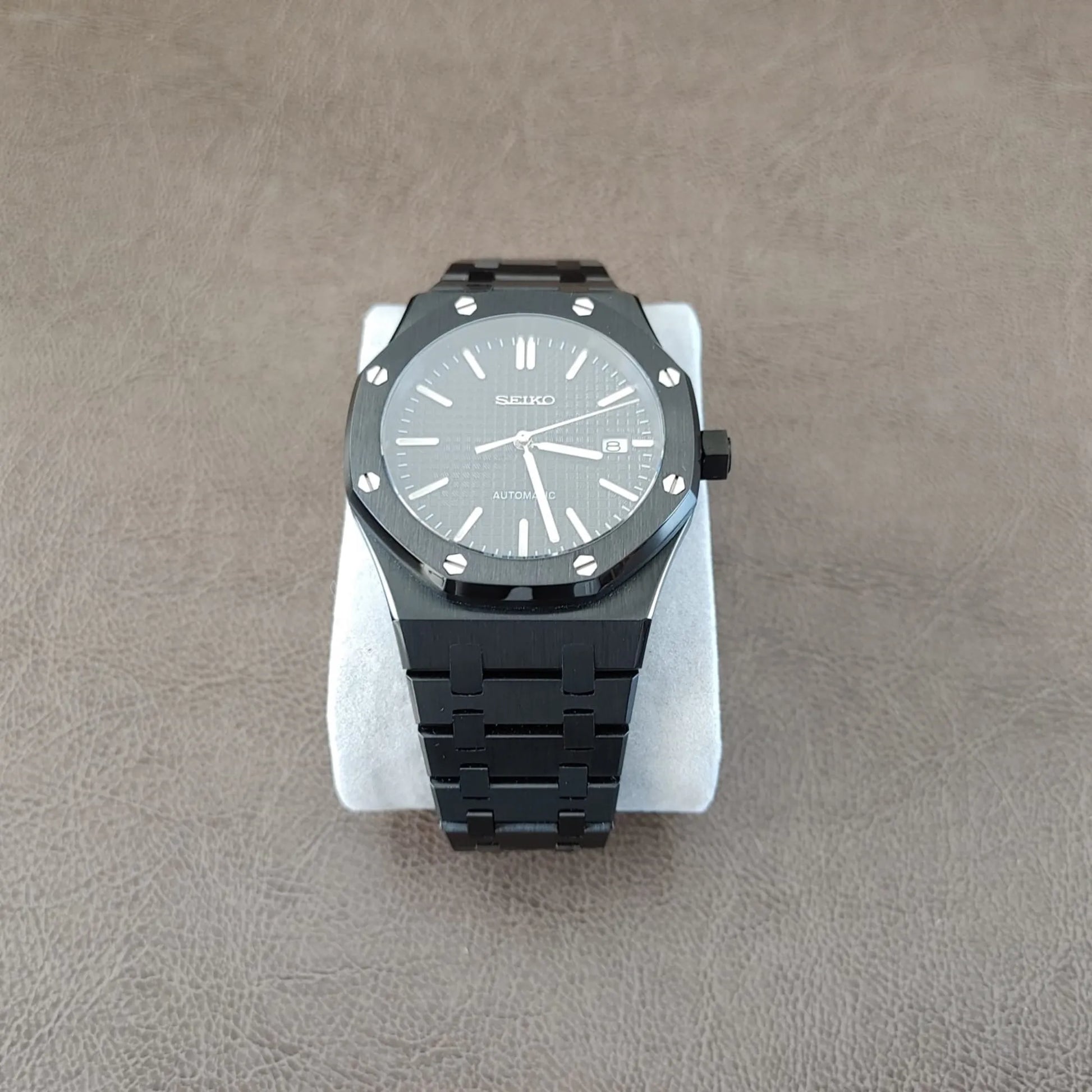 Seiko NH35 Royal Oak 41mm watch with black dial, silver hour markers, black bezel with screws, and black metal bracelet.