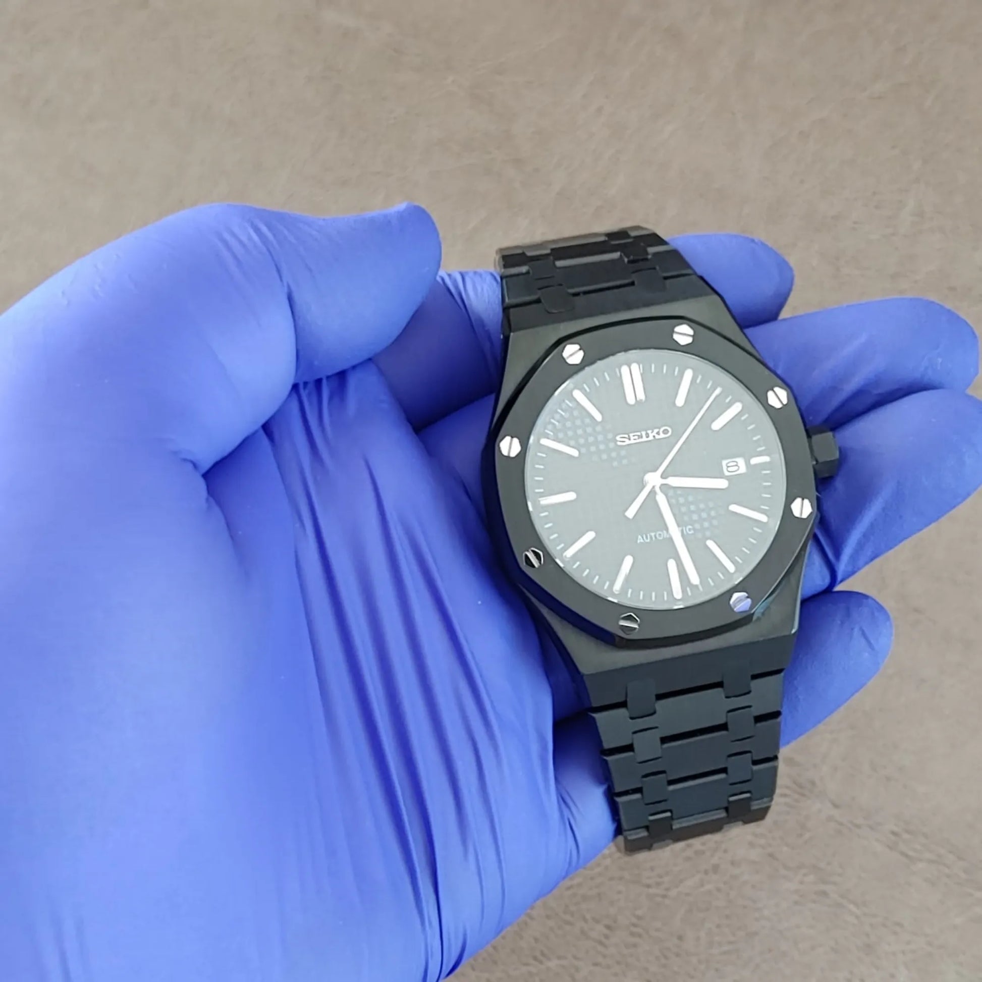 Black and silver Seiko NH35 Royal Oak style watch with octagonal bezel and metal bracelet.
