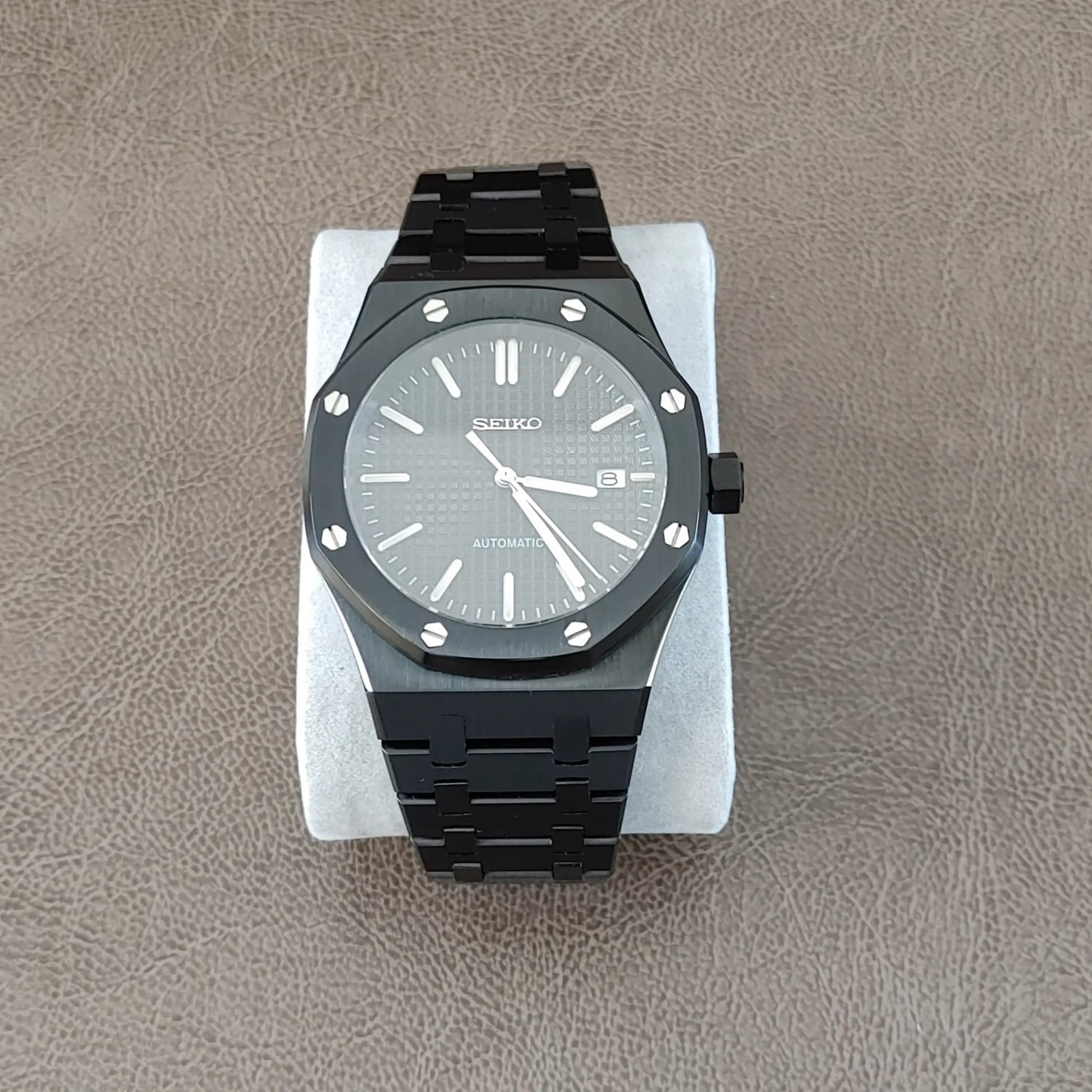 Black stainless steel Royal Oak style watch with silver hour markers and hands, 41mm round case with hexagonal screws.
