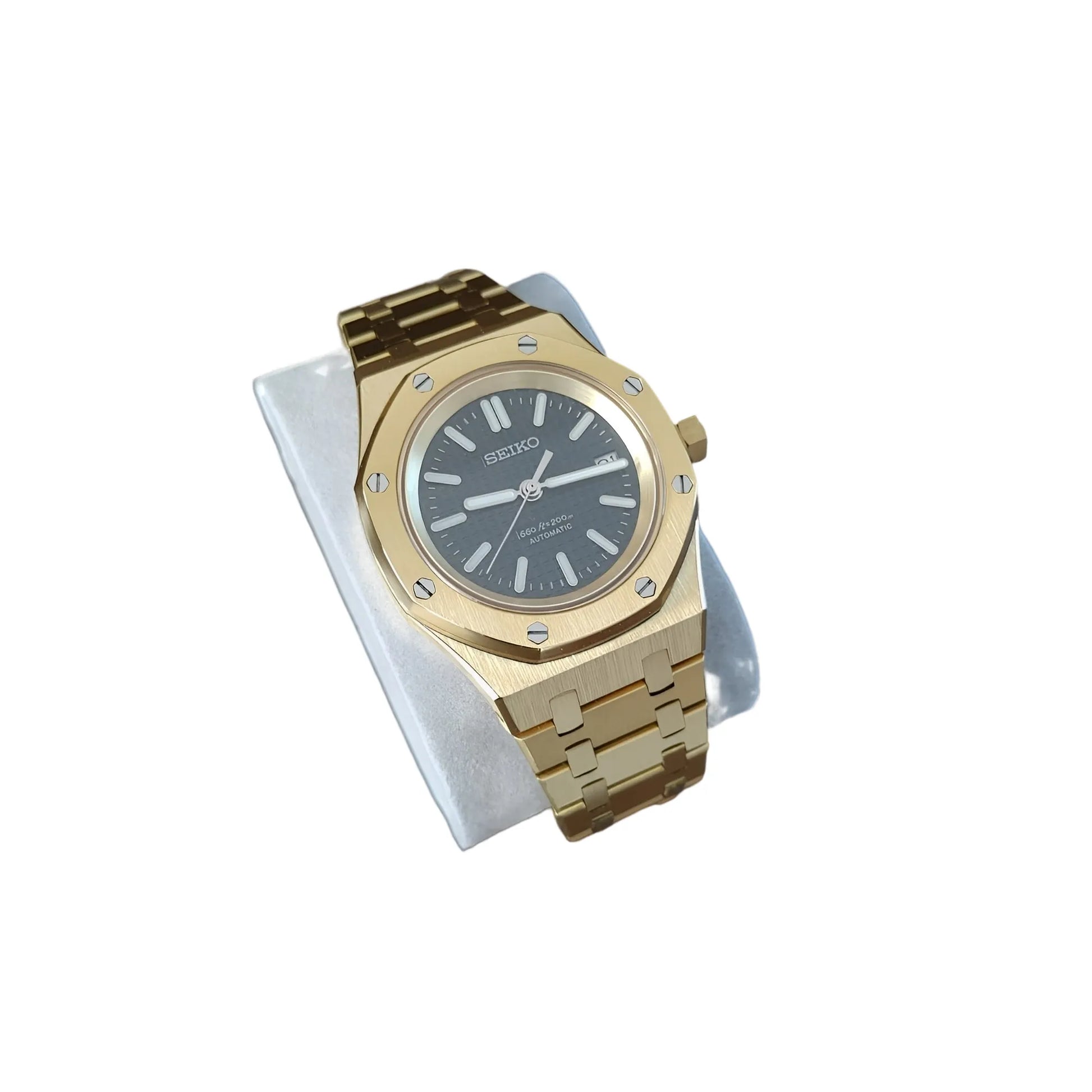 41mm gold-tone watch with black dial, gold hour markers, and linked bracelet on white cushion.