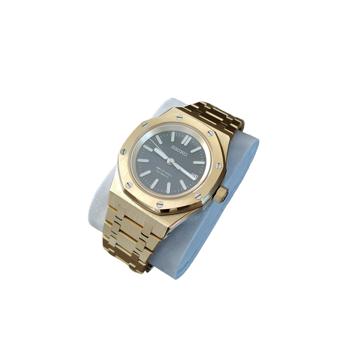 41mm gold-tone stainless steel watch with black dial and metal link bracelet on gray cushion.
