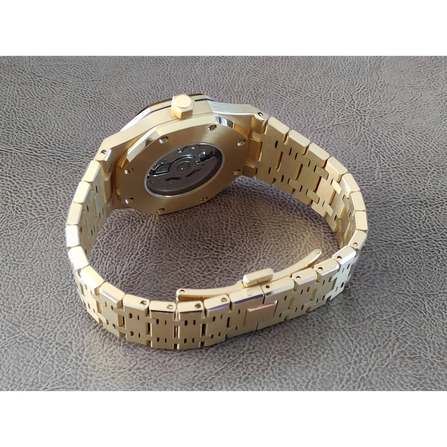 Gold stainless steel watch band with visible case back and black inner mechanism detail.