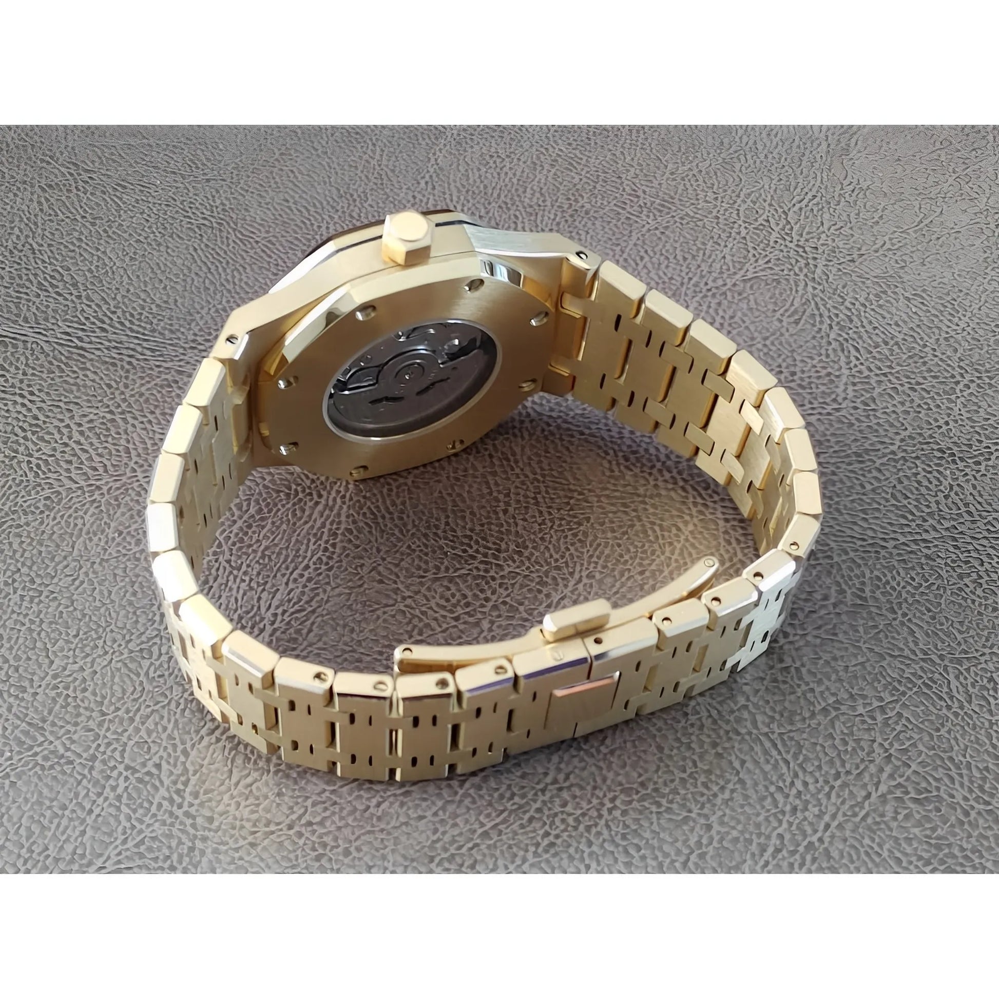 Gold stainless steel watch band with visible case back and black inner mechanism detail.