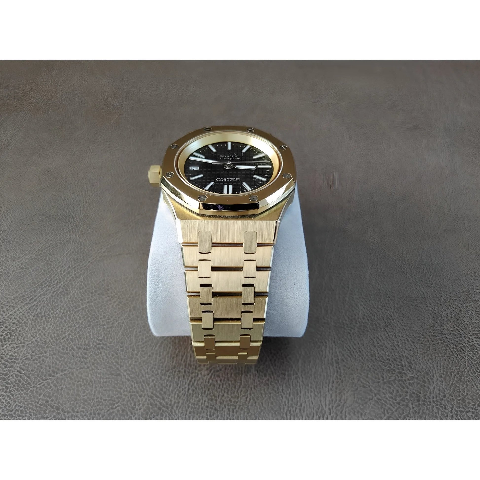 Gold stainless steel Royal Oak style watch with black dial, luminous hands, and link bracelet.