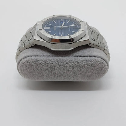 Seiko NH35 watch with navy blue octagonal dial, silver stainless steel case, and linked bracelet on a gray cushion.