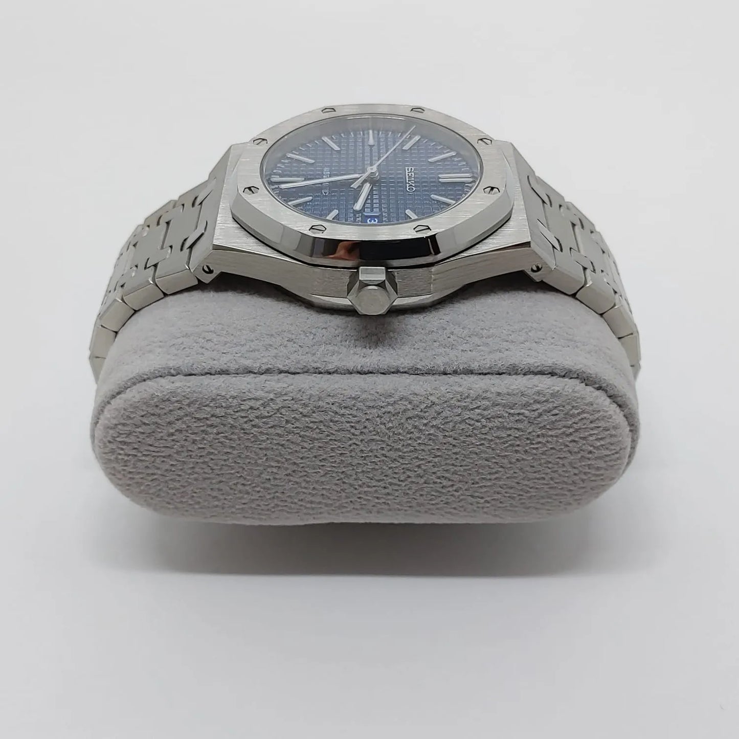Silver stainless steel watch with octagonal bezel, navy blue dial, and silver bracelet.